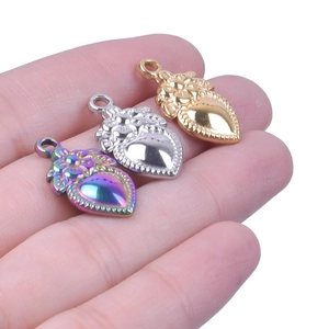 Detailed close-up of 18k gold heart-shaped strawberry floral pendants held by hand