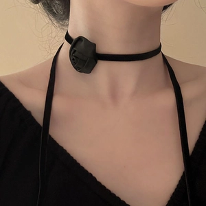 Close-up of elegant black fabric rose choker necklace on model neck with minimalist style