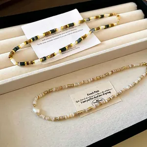 Gold plated beaded necklace with freshwater pearls and natural stones on jewelry tray