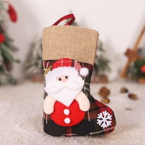 Detail of red and green plaid Christmas stocking with 3D Santa and beige burlap cuff