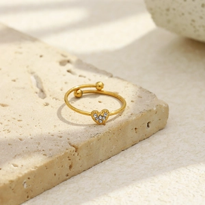 Dettaglio dell'anello a cuore placcato oro 18 carati con cristalli su fondo in pietra