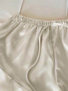 Détail d'un short en satin champagne montrant la taille élastique et le cordon en soie