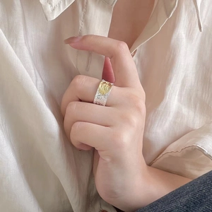 Detail of 925 sterling silver chunky ring with gold relief on textured two-tone band