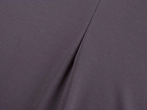 Macro close-up showing the fine texture and stitching of the dark purple fitness fabric