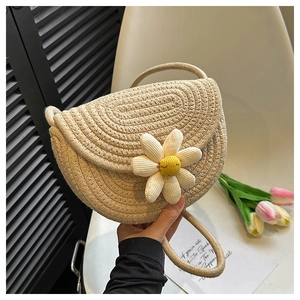 Detailed close-up of a woven daisy saddle bag with beige texture and floral accents