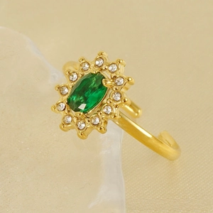 Detailed macro view of 18K gold plated sunflower ring with oval green emerald and zircons