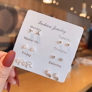 Detail of 6-pair earrings set on card showing bow, pearl, and floral designs