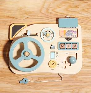 Detail view of wooden busy board with blue steering wheel and interactive gear shift