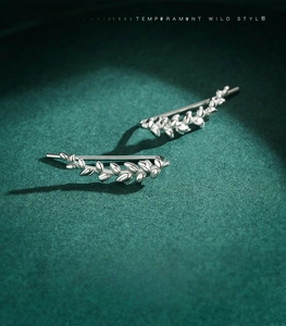 Macro view of 925 sterling silver leaf earrings with detailed botanical design