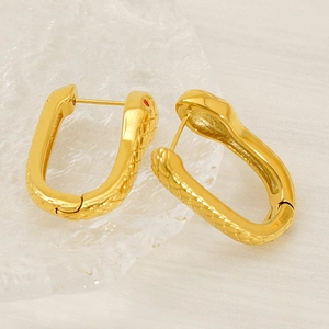 Gold snake huggie earrings with textured scale patterns and red crystal accents