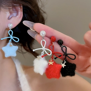 Detailed view of velvet star earrings with bows and pearls in four vibrant colors