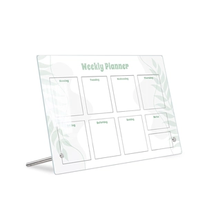 Macro shot of acrylic weekly planner with green leaf motifs and gold metal stand