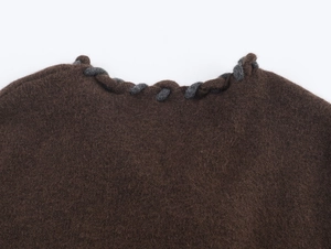 Détail du cardigan en laine marron foncé avec bordures tressées grises en maille torsadée