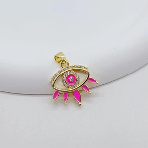 Pink evil eye charm with gold plating and zircons displayed on a white stand