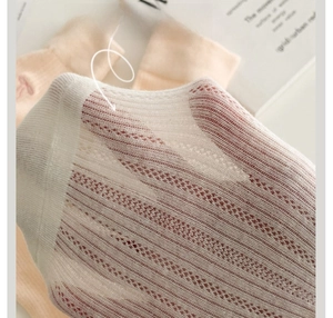 Gros plan sur la maille filet respirante et douce avec motifs ajourés rayés