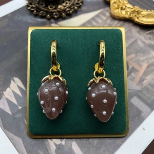 French retro strawberry pearl drop earrings in red and gold on luxury green velvet stand