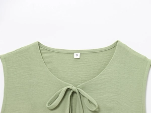 Close-up of green lace-up neckline showing textured fabric and size S label detail
