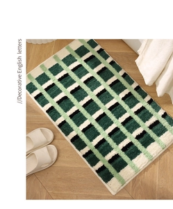 Détail du tapis de bain à carreaux vert et blanc avec texture pelucheuse épaisse