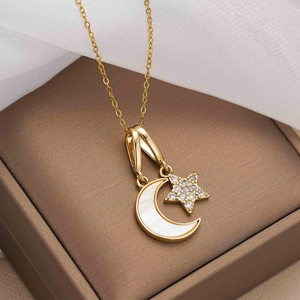 Macro shot of gold star and crescent moon pendant with shell inlay on a jewelry box