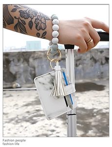 Detail of marble pattern PU card holder with silicone bead wristlet and tassel charm