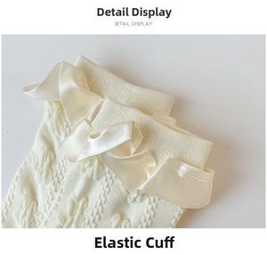 Close-up of cream knit socks featuring elastic cuffs and elegant satin ruffle lace trim