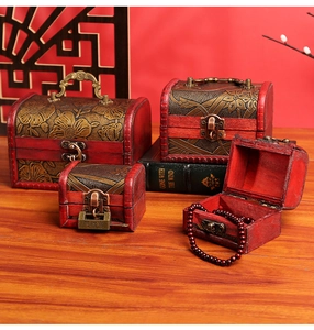 Detailed view of stackable vintage wooden jewelry boxes with ornate carvings and bronze clasps