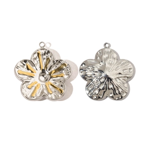 Detailed macro view of two-tone stainless steel daisy pendants with silver and gold accents