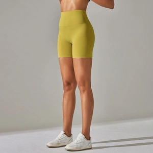 Detail of ginger yellow high waist yoga shorts with peach lift and tummy control feature