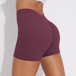Detail of high waisted yoga shorts in dark wine red with ruched scrunch butt design