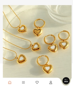 Detailed view of a gold heart jewelry set including necklaces and shell earrings