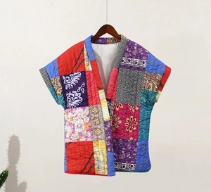 Detail of ethnic print patchwork quilted vest with sleeveless design on wooden hanger
