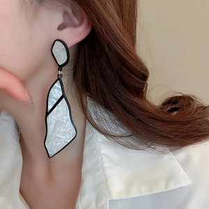 Macro detail of geometric marble acrylic earrings shown on model for elegant style