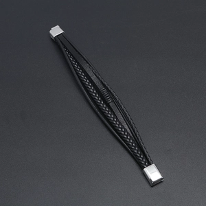 Close-up of black braided leather layers with silver stainless steel magnetic clasp