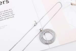 Detail of silver titanium steel necklace with circular pendant and radiating zircons