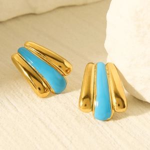 Macro view of vintage style gold-plated earrings with sky blue drip oil glaze texture