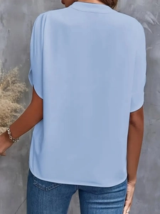 Detail view of light blue loose chiffon blouse back texture with short sleeves
