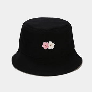 Detail of pink and white cherry blossom embroidery on a black cotton bucket hat