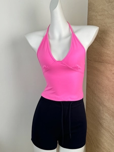 Detail of rose red halter neck crop top and black drawstring shorts on mannequin