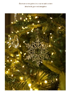 Detail of crystal snowflake ornament hanging on a Christmas tree with warm fairy lights