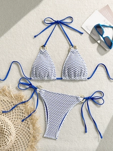 Detailed view of bikini top with wooden ring decoration and textured grid fabric