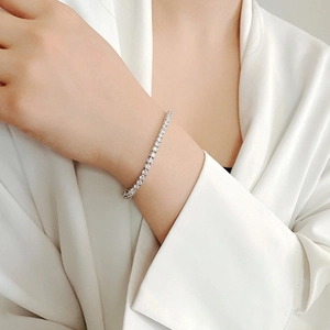 Silver tennis bracelet with sparkling zircons shown on model with elegant silk background