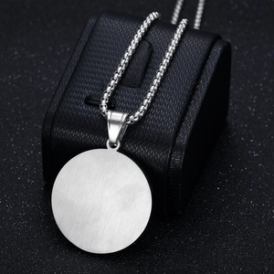 Polished silver stainless steel necklace with round blank pendant on black display