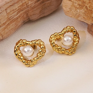 Élégantes boucles d'oreilles cœur dorées avec bord torsadé et perle sur fond de pierre