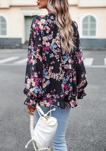 Vista posteriore della camicetta elegante in chiffon nero a fiori con maniche a volant
