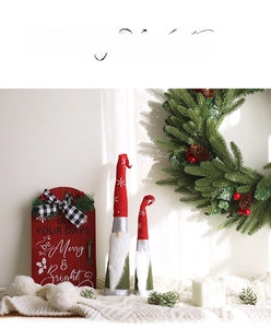 Close-up of plush Christmas gnomes with festive red star hats and wooden holiday sign