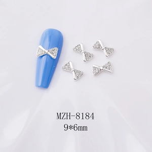 Nœud décoratif argenté avec strass pour nail art sur faux ongle bleu ciel