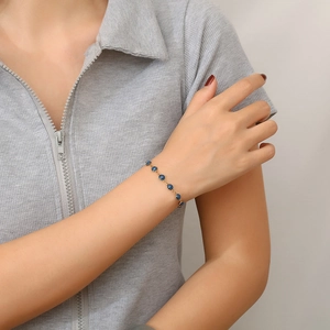 Bohemian gold stainless steel bracelet featuring round dark blue gemstones on model wrist