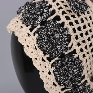 Close-up of handmade crochet headband featuring 3D floral accents on a mesh net base