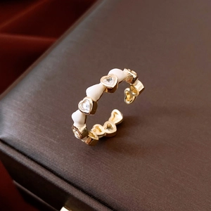 Detail of 14K gold plated heart ring featuring white enamel and crystal accents