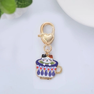 Detailed view of colorful enamel cat in coffee cup charm with heart lobster clasp